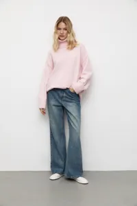 Détail pull col roulé rose en tricot, style ample et décontracté pour femme en hiver.