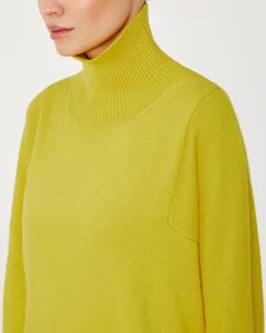 Close-up detail of women's cozy yellow turtleneck knit sweater showing fine texture.