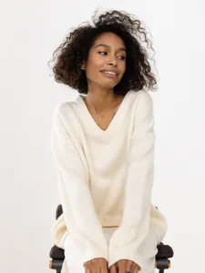 Detailed view of the cozy V-neck oversized knit sweater in cream, showcasing soft texture.