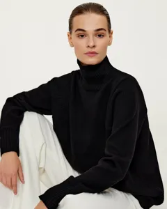 Detail view of a cozy black turtleneck knit sweater, loose fit autumn winter women fashion.