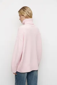 Détail de pull en tricot à col roulé rose avec coupe ample et confortable et douce texture