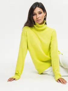 Closeup view of the cozy neon green turtleneck sweater, showing soft knit texture and collar.