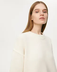 Close-up detail view of women's soft crewneck knit sweater, cozy loose fit knitwear texture.