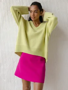 Close-up detail of women's casual V-neck loose long-sleeve knit sweater in bright lime green.