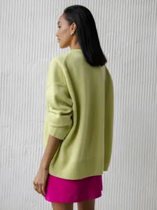 Detail view of a stylish lime green knit sweater, relaxed long-sleeve winter apparel.