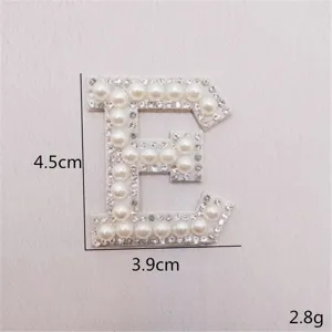 Nahaufnahme des Strass-Perlen-Buchstaben E Aufnähers, glänzendes DIY Bekleidungszubehör.