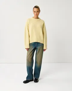 Details of casual crewneck loose knit sweater in soft light yellow for autumn season.
