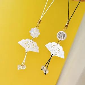 Gros plan sur le pendentif éventail en coquillage vintage avec perles et cristaux fins.