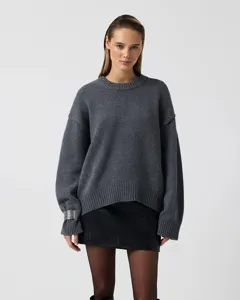 Detailed view of the dark grey knit sweater showcasing crew neck, ribbed cuffs and loose fit.