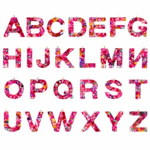 Resin alphabet letter pendant detail, colorful shell glitter DIY jewelry accessory close up.