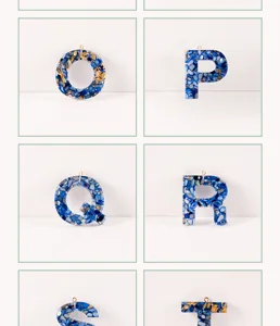 Detailansicht blauer Harz Alphabet Buchstaben Anhänger mit Goldflocken und Mosaik für DIY.