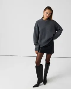Casual grey crew neck knit sweater detail showcasing loose fit long sleeves and texture.