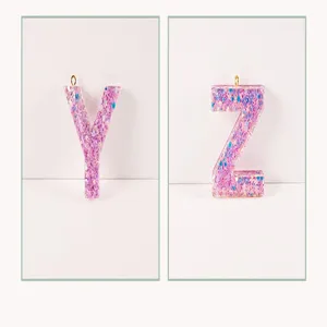 Close-up detail view of glitter resin alphabet letter pendant charm for custom DIY keychains.