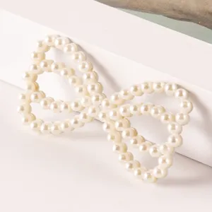 Elegante parel strik haarspeld DIY accessoire, perfect voor stijlvolle handgemaakte haarversiering.