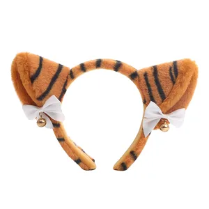 Close-up detail of the plush tiger ear headband with cute bow and tiny bell ornament.