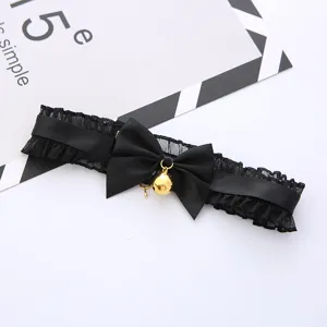 Black lace choker necklace with bow and gold bell, cute cat style gothic fashion accessory.