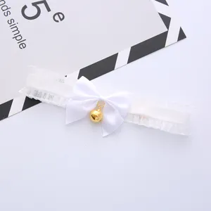White lace choker necklace with cute bow and gold bell, sweet style accessory detail view.