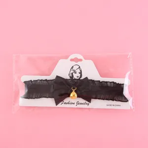 Black lace choker necklace with bow and bell for women, sweet and gothic jewelry accessory.