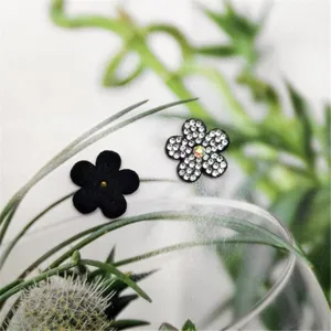 Gros plan de pendentifs de chaussures de fleurs noires et en strass DIY pour accessoires.