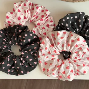 Detalles en primer plano de coleteros con motivo de corazón, tela suave y elástica.