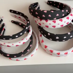 Vista detallada de elegantes diademas de tela coreana con bonitos estampados de corazones.