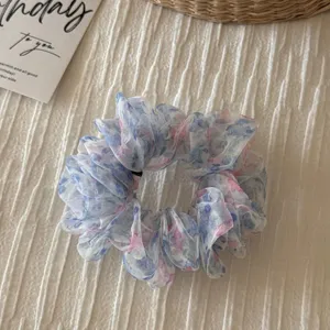 Close-up of vintage floral organza hair scrunchie, elegant sweet hair tie accessory for women.