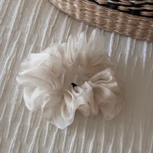 Detailed close-up of a Korean solid white sheer organza scrunchie, soft hair tie accessory.