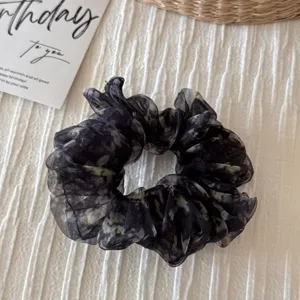 Dark floral organza scrunchie detail close-up showcasing fluffy texture and elegant retro style.