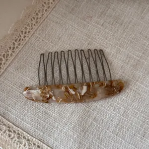 Detail shot of elegant tortoiseshell acetate hair comb with metal teeth, perfect daily accessory.