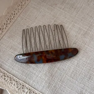 Detail view of exquisite acetate hair insert comb, tortoise shell design, elegant hair accessory.