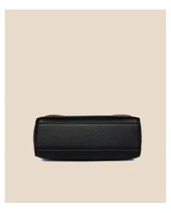 Detailaufnahme des Bodens einer schwarzen Handtasche aus weichem Leder mit feiner Textur.