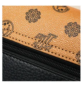 Detailansicht der Vintage Damentasche mit braunem Monogrammdruck und schwarzem Leder.