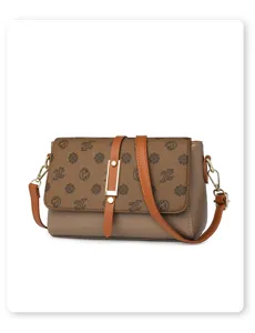 Detail shot of vintage brown leather crossbody bag with monogram flap and metallic buckle clasp.