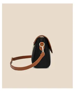 Black and brown leather crossbody bag with adjustable strap and gold hardware detail.