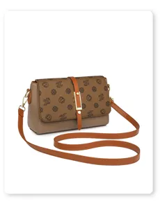 Detailed view of the brown leather crossbody bag featuring a stylish monogram flap and buckle.