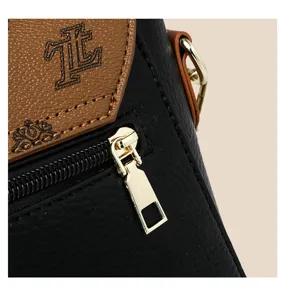Detailed view of women crossbody bag featuring black soft leather, brown flap and gold zipper.