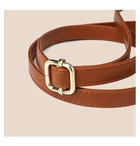 Close-up detail of adjustable brown PU leather shoulder strap with gold metal buckle.