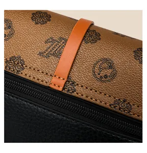 Detailed close-up view of two-tone fashion crossbody bag with monogram print and zipper.