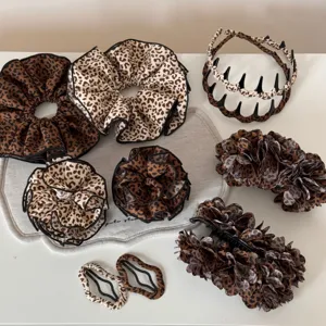 Set di accessori per capelli con stampa leopardata alla moda, inclusi elastici e mollette.