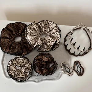 Set di accessori per capelli con stampa leopardata retrò, scrunchies, cerchietto e mollette.