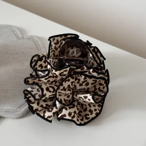 Primo piano di un elegante fermacapelli con stampa leopardata e bordo nero per acconciature.