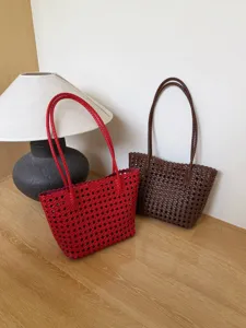Vue détaillée du sac fourre-tout tressé en cuir souple, design ajouré et style chic décontracté.