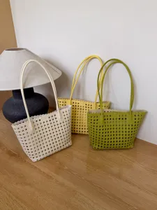 Vue détaillée de sacs cabas tressés ajourés tendance en beige, jaune et vert.