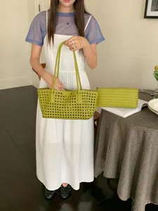 Green woven tote bag and clutch set with hollow design, elegant shoulder bag for summer travel.