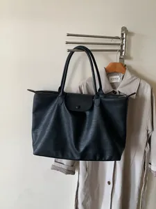 Schwarze Pendler-Tasche Detailansicht mit grossem Fassungsvermoegen, stabilen Griffen und Klappe.