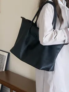 Schwarze Pendler-Tasche Detailansicht mit feiner Textur und hochwertigen Griffen.
