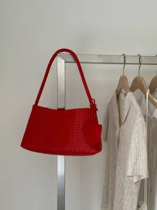 Red woven leather shoulder bag detail shot, elegant handbag style for daily commute and fashion.