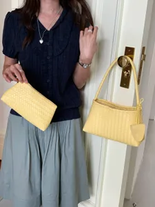 Detailed lifestyle showcase of yellow woven leather shoulder baguette bag and clutch bag.