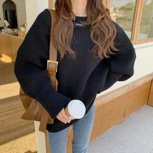 Maglione lavorato a maglia nero casual abbinato a jeans blu e borsa tote marrone dettaglio