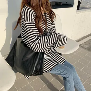 Vista dettagliata della borsa tote minimalista in pelle nera, con grande capienza.